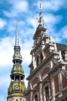 view of sacred Peter church steeple and central square building of Riga old town, Lativa. Blue cloudy sky in background