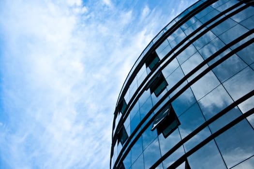 modern office building glass facade with reflection of sky and cloudy sky0