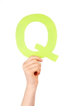 the letter Q, hold by a hand, isolated