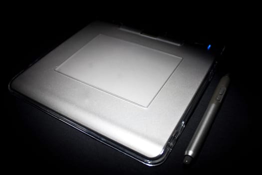 white tablet with stylus fading into black background