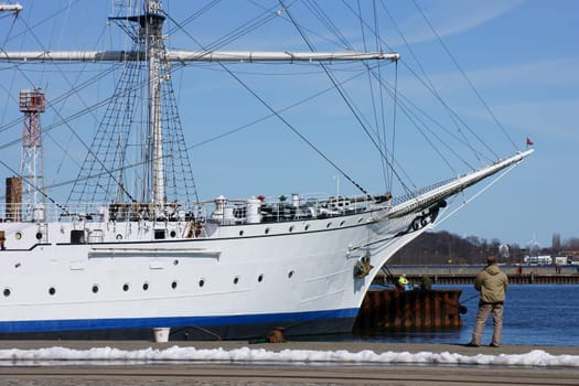 Stralsund, Mecklenburg Vorpommern/Deutschland  – April 06, 2013: Touristen besichtigen und Angler angeln an der Gorch Fock am 06. April 2013 im Hafen von Stralsund. Die Gorch Fock ist ein Segelschulschiff der deutschen Marine.