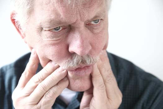 senior man with pain in his teeth or cheeks