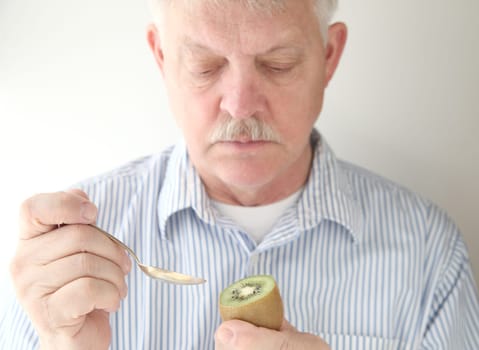 older man with fruit and spoon