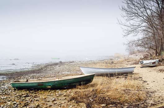 Old fishing boat at coast foggy in the morning