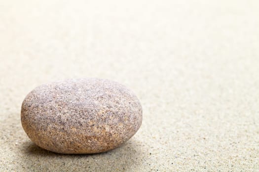 Beige stone in sand. Nature background with copy space. Macro shot