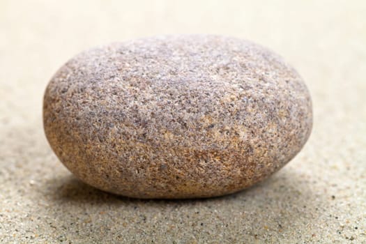 Beige stone in sand. Nature background. Macro shot