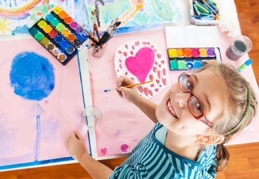 Schoolgirl painting with water color - top view