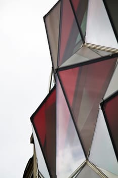 View of a curious modern building with red glass windows.