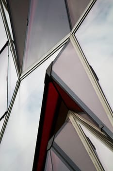 View of a curious modern building with red glass windows.