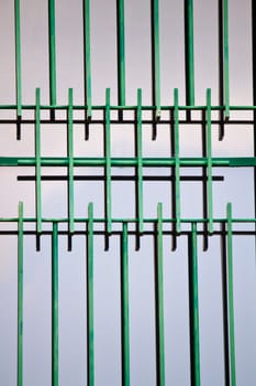 Close up view of a window with iron green bars.