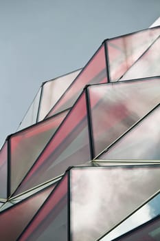 View of a curious modern building with red glass windows.