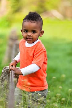 Outdoor portrait of a cute young  little black boy playing outside - African people