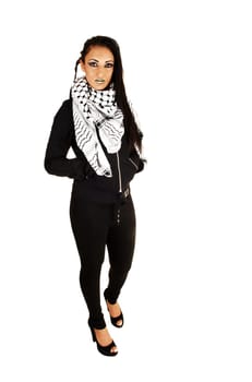 A teenage girl in black tights and jacket and a scarf around her neck, standing for white background.