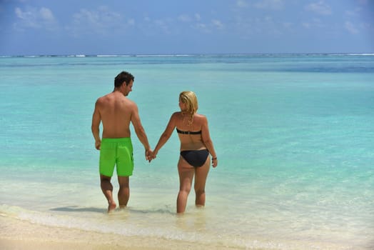 happy young  couple at summer vacation have fun and relax at beautiful sunny  day on beach