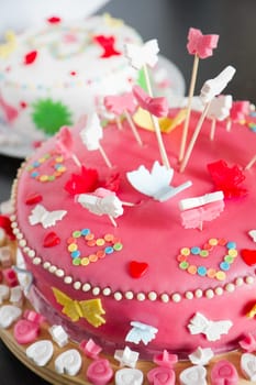 Colorful decorated white and pink Marzipan cakes for a birthday party on kitchen dresser - close up with shallow dof
