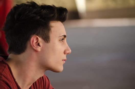 Attractive young man's side view portrait. Profile shot, outdoors