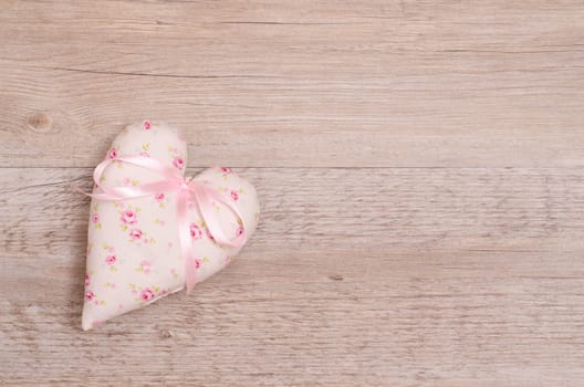 Heart with pink bow and text space on old wood