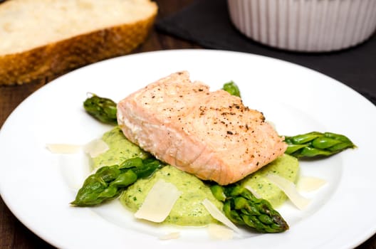 Salmon fillet and green asparagus on a white plate