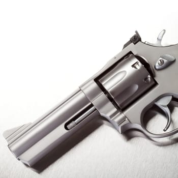 Handgun on brushed metal background, white above