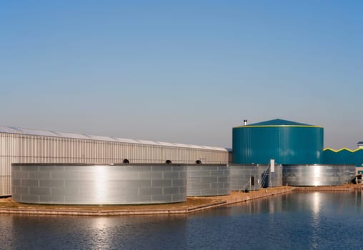 Greenhouse and water tank under a clear blue sky