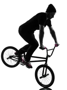 one caucasian man exercising bmx acrobatic figure in silhouette studio isolated on white background