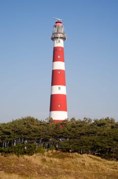 Iconic red and white lighthouse in the dunes of Ameland, the Netherlands