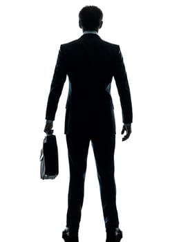 one caucasian businessman standing rear view  in silhouette studio isolated on white background