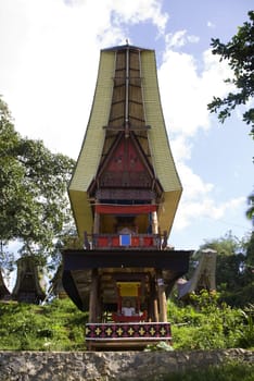 Wood carved effigy, called tau tau placed in a tongkonan looking over the land
