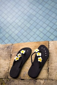 Two flip flops near the swimming pool