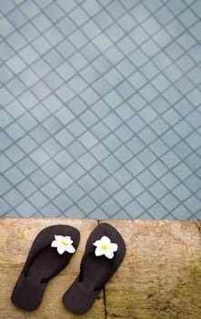Two flip flops near the swimming pool