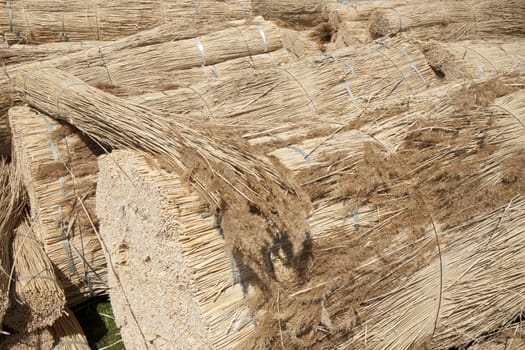 Big bundles of dried reed ready to be used on a thatched roof