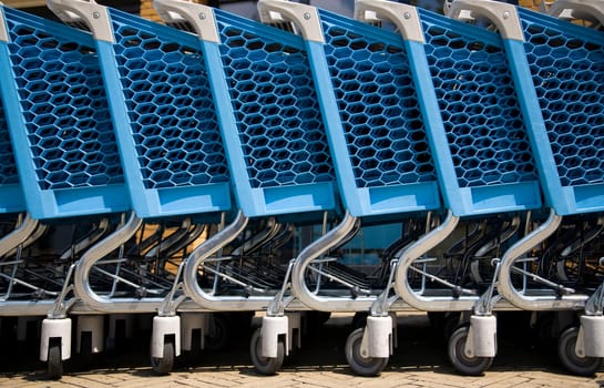 Blue plastic shopping carts in a row