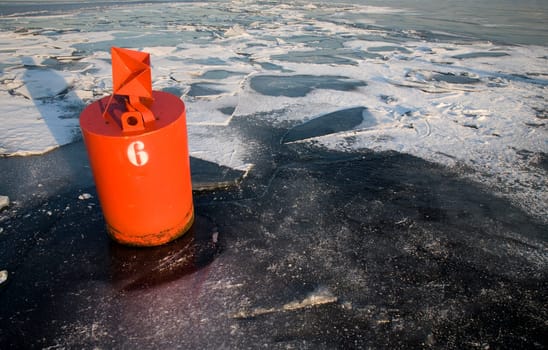 Ice landscape with orange buoy and floes