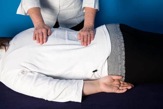 A young woman is getting a reiki treatment