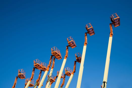 Cherry pickers against a blue sky