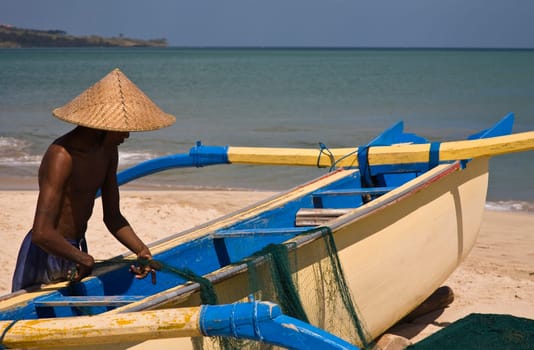 Fisher with fishing boat in Jimbaran bay, Bali