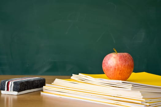 Still life of a teachers desk with a blackboard in the background