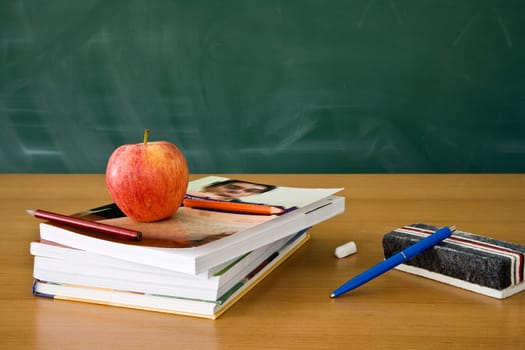 Still life of a teachers desk with a blackboard in the background