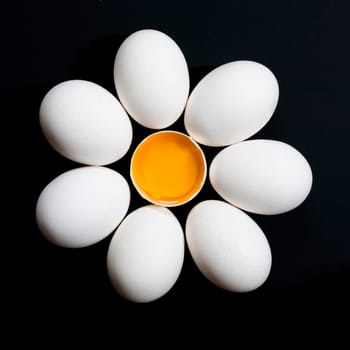 Still life of white eggs and a broken egg in the middle