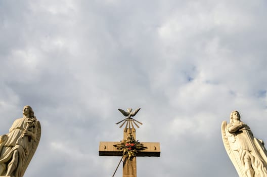 Two angels and a cross with an overcast sky