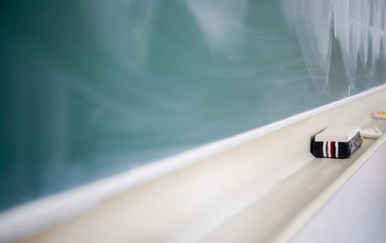 Used green chalkboard with eraser and chalk