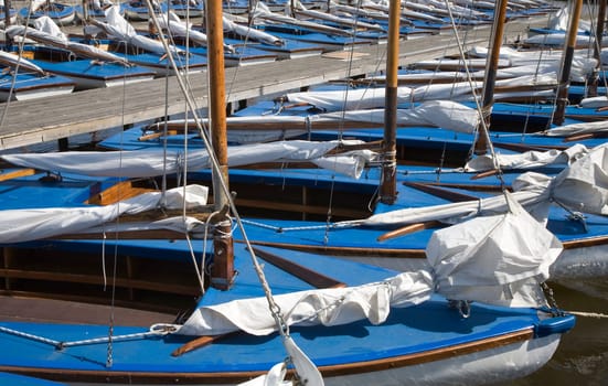 Many blue sailing boats in the marina