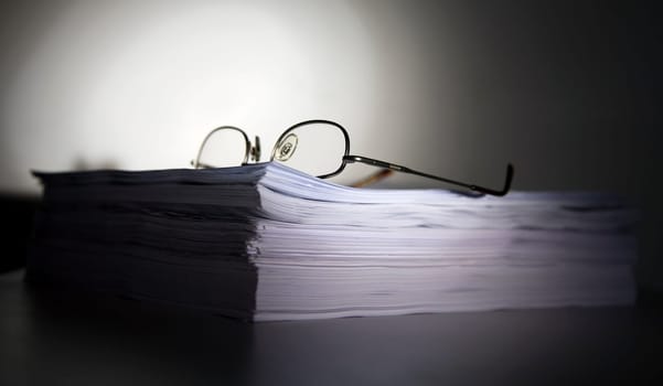 Pile of files with glasses