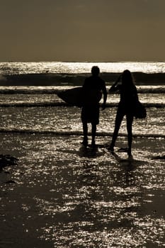 Surfers sunset at Uluwatu beach, Bali