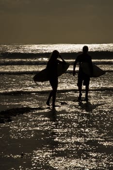 Surfers sunset at Uluwatu beach, Bali