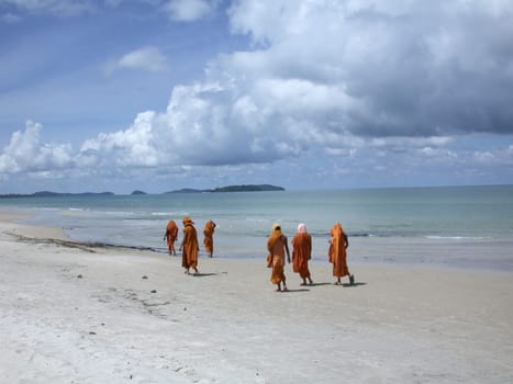 Buddhist monks walking over a beach in Cambodia