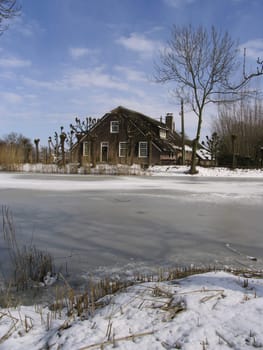 Old Dutch farm house in winter landscape