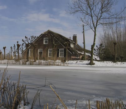 Old Dutch farm house in winter landscape