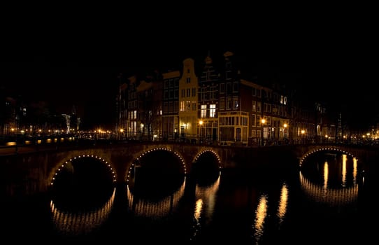 Canal junction at night in Amsterdam,Holland