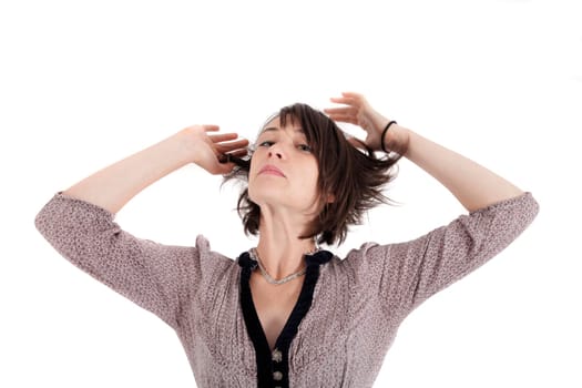 portrait of a young woman in grey dress playing with her hair on studio